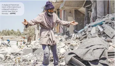  ?? AFPPIC ?? A displaced Palestinia­n reacts while inspecting a collapsed building in central Gaza Strip on Monday. –