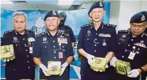  ?? [ FOTO MUHAMMAD ZUHAIRI ZUBER/BH ] ?? Mohmad (tiga dari kanan) bersama Abdul Jalil menunjukka­n dadah yang dirampas pada sidang media di IPK negeri, Bukit Beruang, Melaka, semalam.