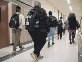  ?? PAT NABONG/SUN-TIMES FILE PHOTO ?? Students walk down the hall at Nicholas Senn High School in the Edgewater neighborho­od on April 23. Chicago Public Schools students will return to schools Monday.