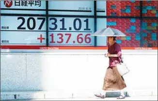  ??  ?? A woman walks past an electronic stock board showing Japan’s Nikkei 225 index at a securities firm in Tokyo on Aug 9. Asian shares rose Friday as investors bought back stocks following gains on Wall Street, although worries
about a trade dispute between the US and China remained. (AP)
