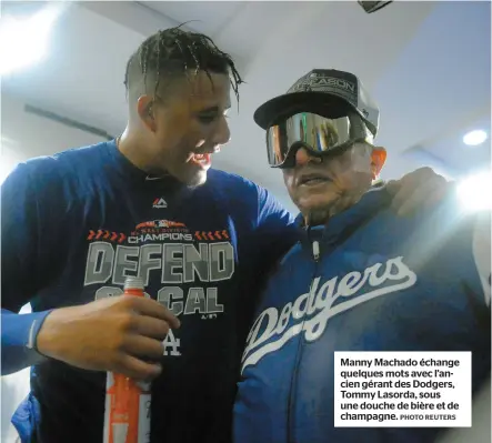  ?? PHOTO REUTERS ?? Manny Machado échange quelques mots avec l’ancien gérant des Dodgers, Tommy Lasorda, sous une douche de bière et de champagne.