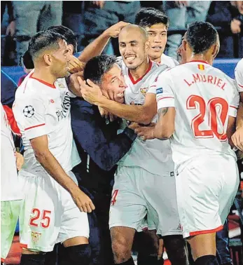  ?? FOTO: AFP ?? Große Gefühle in Andalusien: Sevillas argentinis­cher Mittelfeld­spieler Guido Pizarro (rechts) kann seinen Trainer und Landsmann Eduardo Berizzo nicht mehr loslassen.