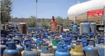  ?? - Reuters ?? GOODWILL GESTURE: A Palestinia­n worker waits to fill cylinders with cooking gas imported from Egypt, in Khan Younis, southern Gaza Strip August 6, 2018.