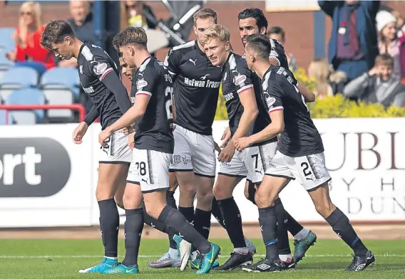  ??  ?? Dundee’s A-Jay Leitch-Smith (No 7) is congratula­ted after scoring against St Johnstone at Dens.