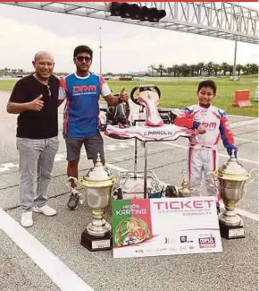  ??  ?? Adam Mikail (right), Malaysia’s latest Asian karting champion, with his trophies. With him is his father Mazrul Haizad Marof (left).