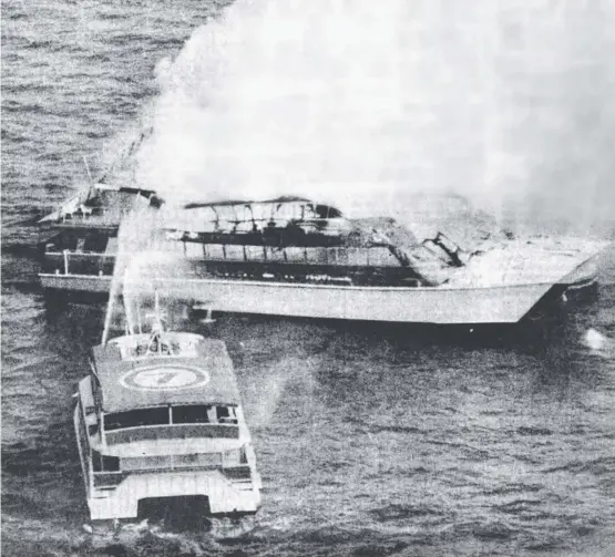  ?? Picture: MICHAEL PRATT ?? TACKLING FLAMES: Firefighte­rs on board the Magnetic Explorer direct water on the stricken Reef Link
II in Cleveland Bay.