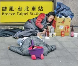  ?? Chris Stowers For The Times ?? OUTSIDE the main train station in Taipei, homeless people drink cooking wine. In Mandarin, they’re called “wandering people” or “street friends.”