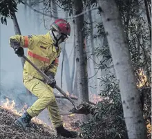  ?? JAVIER FERGO THE ASSOCIATED PRESS ?? Emergency services in Portugal say they are still fighting a major wildfire on the south coast that threatened to engulf a hillside town overnight.