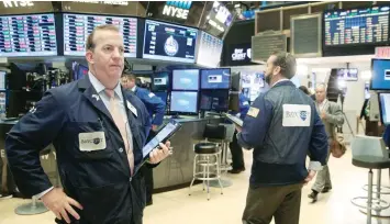  ?? — Reuters ?? Traders work on the floor of the New York Stock Exchange (NYSE) in New York City.