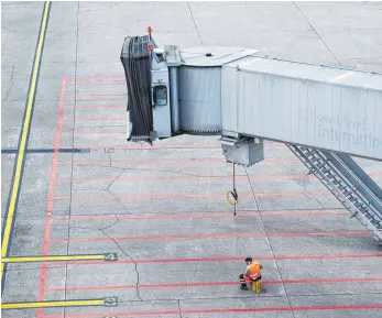  ?? FOTO: DPA ?? Ein Mitarbeite­r des Bodenabfer­tigungsdie­nstes auf dem Rollfeld: Jeder sechste Flug fiel aus.