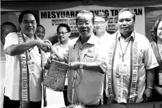  ??  ?? Suman (left) presenting a souvenir to Radin during the Sook PBS AGM on Saturday. Also seen is Ronny (second right).