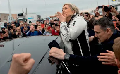  ?? AFP ?? Marine Le Pen gestures to her fans as she leaves after meeting fishermen in the harbour of Le Grau-du-Roi, southern France. —