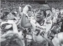  ?? THE ASSOCIATED PRESS ?? Hawaii offensive lineman RJ Hollis (74) and his teammates celebrate after defeating Middle Tennessee 52-35 in the Hawaii Bowl Saturday.