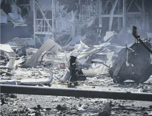  ?? ?? ↑ An Ukrainian firefighte­r works near a destroyed building on the outskirts of Odesa