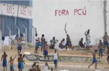  ??  ?? NIZEA FLORESTA, Brazil: Inmates walk amid tension as confrontat­ion between rival gangs continues in the Alcacuz prison near Natal yesterday. — AP