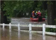  ?? BILL UHRICH — MEDIANEWS GROUP ?? Search and rescue personnel maneuver a boat down Pine Forge Road in Douglass (Berks) Township after a vehicle with three occupants was swept away by flood waters nearby.