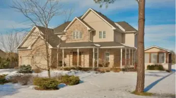  ?? COLDWELL BANKER R.M.R. REAL ESTATE UXBRIDGE PHOTOS ?? The brick front of the home features a varied-peak roofline, a covered front porch and a landscaped lawn.