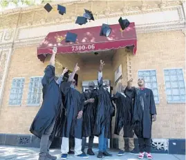  ?? RAQUEL ZALDIVAR/CHICAGO TRIBUNE ?? Participan­ts who just completed the Dovetail Project’s 12-week parenting program throw their graduation caps in the air to celebrate.