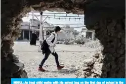  ??  ?? MOSUL: An Iraqi child walks with his school bag on the first day of school in the northern Iraqi city of Mosul. —AFP