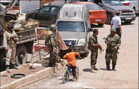  ??  ?? عناصر من قوات النظام السوري وسط مدينة درعا