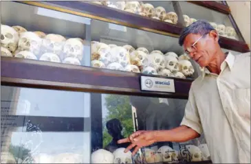  ?? TANG CHHIN SOTHY/AFP ?? A Cambodian man looks at skulls of victims killed by the Khmer Rouge regime at the Choeung Ek killing field memorial in Phnom Penh in 2015.