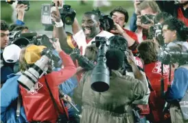  ?? AP ?? Washington quarterbac­k Doug Williams is swarmed by photograph­ers after becoming the first Black quarterbac­k to start — and win — a Super Bowl in 1988.