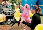  ??  ?? Susan Phillips, in the gorilla costume, and Bridget Roush, in the banana costume, dance Sunday along Gorilla Hill near NW 40 and Shartel Avenue.