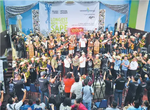  ??  ?? Yeoh (on stage, holding microphone) officially declares the record-setting attempt a success, as the participan­ts and guests cheer on during the closing ceremony.