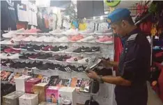  ??  ?? PEGAWAI KPDNHEP melakukan rampasan terhadap barangan cetak rompak dijual di Bukit Bintang, semalam.