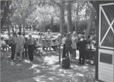  ??  ?? Attendees enjoy cake and refreshmen­ts at the McLatchie house centennial celebratio­n, Aug. 4.