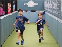  ?? CURTIS COMPTON/CCOMPTON@AJC.COM ?? Gavi Surden (left), 10, who has autism, races his brother Noah, 6, in the first-base dash at the kid-friendly area of SunTrust Park while taking part in the Braves Exceptiona­l Fans Program.