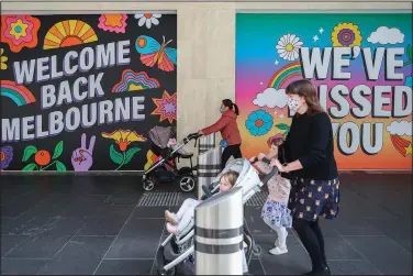  ?? (File Photo/AP/Asanka Brendon Ratnayake) ?? Women wearing face masks push strollers past signs Oct. 28, 2020, in Melbourne, Australia. Stories circulatin­g online incorrectl­y claim Australia is seeing its sharpest rise in deaths in 80 years because of the coronaviru­s vaccine.