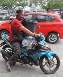  ?? ?? On standby: a resident in Seberang Prai heading back home with a large pail and bottles of drinking water. — Zhafaran Nasib/ The Star