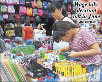  ?? MIGUEL DE GUZMAN ?? A girl picks out pens at a school supply stall in Divisoria, Manila yesterday.