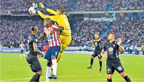  ?? FOTOS JESúS RICO, LUIS RODRíGUEZ ?? El defensor Germán Mera llega al encuentro de la pelota tras un centro, pero el guardameta del América Neto Volpi aleja el peligro.