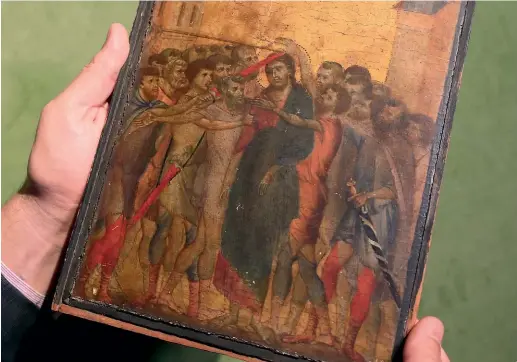  ?? AP ?? Art expert Stephane Pinta holds a 13th-century painting by Italian master Cimabue which has sold for a world record $42 million.