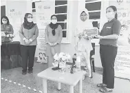  ??  ?? TERIMALAH: Fatimah (dua kanan) menyampaik­an geran kepada Jenny (kanan) sambil diperhatik­an Salina (dua kiri) dan Noriah (kiri) di Kindycare Child Centre, Casa Marbella semalam.