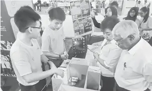  ??  ?? INOVASI: Rahman ( kanan) dan Jong (dua kanan) menilai ciptaan pelajar dari SMK Bintulu pada pertanding­an‘Access to Energy’ peringkat Sarawak di BCCK, semalam.