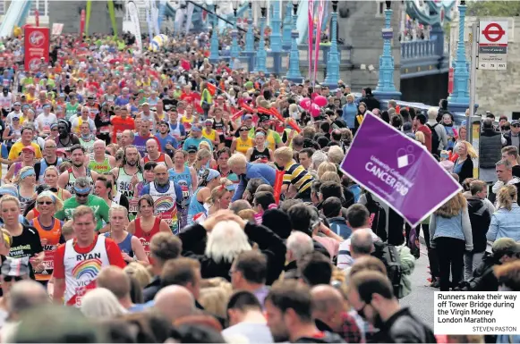  ?? STEVEN PASTON ?? Runners make their way off Tower Bridge during the Virgin Money London Marathon