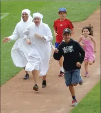  ?? Photo courtesy of Little Sisters of the Poor ?? Members of the Little Sisters of the Poor run the bases at McCoy Stadium during a recent Family Fun Day.