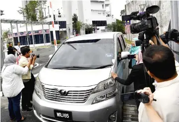  ??  ?? Musa Aman’s transport Toyota Vellfire mobbed by reporters after giving his statement. — Bernama photo