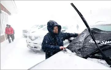  ?? ?? Janine Shaw puts a snow shield on her car window outside of the Mountain Hardware & Sports in Truckee on Saturday.