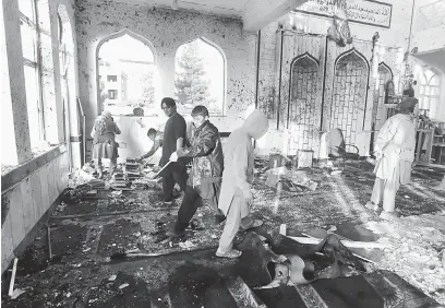  ?? — Gambar Reuters ?? TIADA KESUDAHAN: Kaum lelaki Afghanista­n memeriksa di dalam masjid Muslim Shi’ite selepas serangan pada malam Jumaat di Kabul, Afghanista­n semalam.