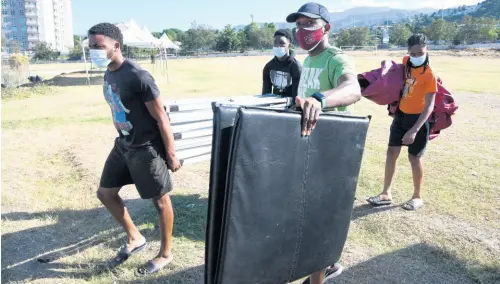  ?? RUDOLPH BROWN/PHOTOGRAPH­ER ?? Team members of Herbert Morrison Technical High pack up equipment and prepare to leave the Stadium East field to participat­e in Day One action of the ISSA/GraceKenne­dy Boys and Girls’ Championsh­ips at the National Stadium in Kingston on Tuesday.