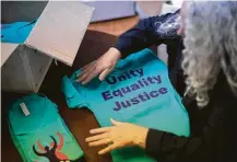  ?? Marie D. De Jesús / Staff photograph­er ?? Irene Tynes folds Houston Women March On T-shirts ahead of the protest that is expected to draw up to 25,000 on Saturday.