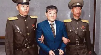  ?? Kim Kwang Hyon / Associated Press ?? Kim Dong Chul, center, a U.S. citizen detained in North Korea, is escorted to his trial on Friday. A North Korean court has sentenced the ethnic Korean U.S. citizen to 10 years of hard labor for what it called acts of espionage and allegedly spying for...