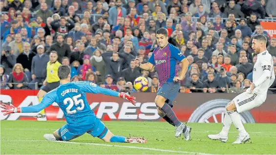  ?? AP ?? Triplete. Luis Suárez define con clase ante el belga Courtois, con Sergio Ramos como testigo. Fue el tercero suyo y el cuarto del Barcelona.