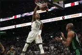  ?? STEVEN SENNE — THE ASSOCIATED PRESS ?? Milwaukee Bucks forward Giannis Antetokoun­mpo (34) dunks as Boston Celtics guard Marcus Smart, left, and center Al Horford, right, look on in the first half of Game 1in a second-round Eastern Conference playoff series Sunday in Boston.