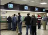  ?? ASSOCIATED PRESS ?? FILE - In this Oct. 21, 2011, file photo, patrons line up to place bets at Freehold Raceway in Freehold, N.J.