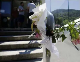  ??  ?? Des bouquets pleurent l’absence de celle qui a chuté en arrosant les fleurs en haut de l’escalier. (Photos Dylan Meiffret)